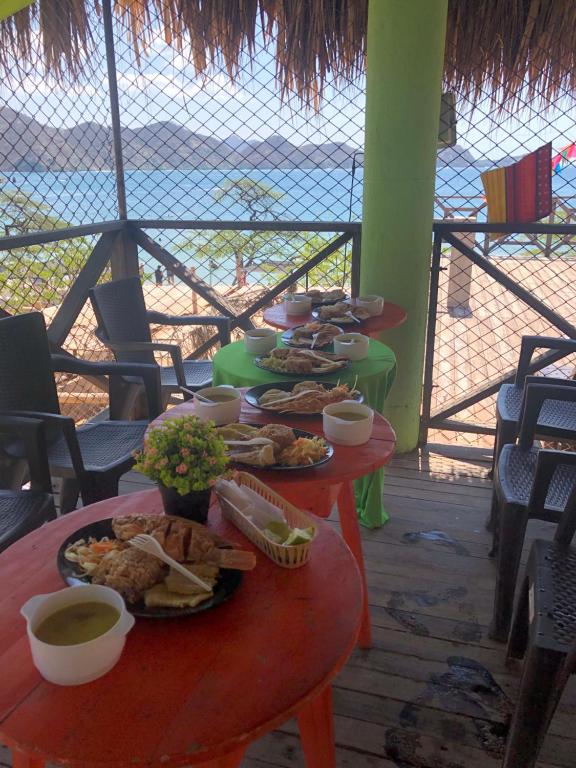 een groep tafels met borden met voedsel erop bij HOSTAL MARIA ISABEL in Santa Marta