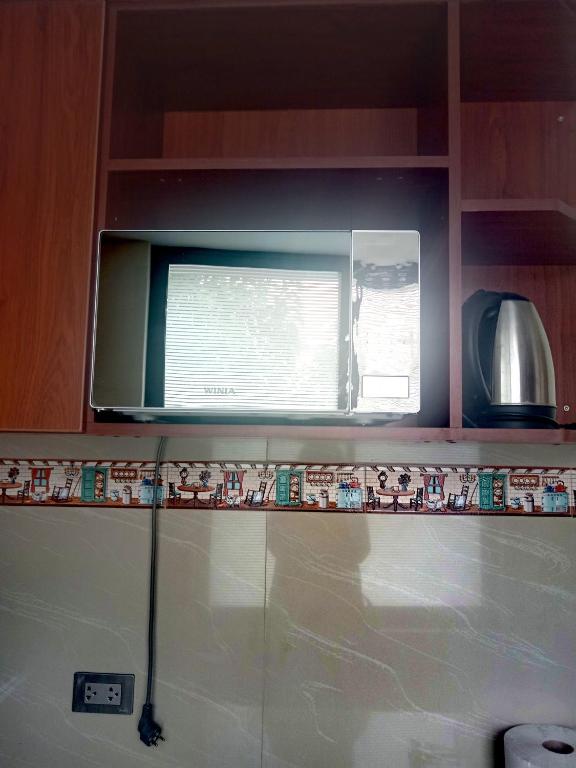 un microondas sobre una barra de cocina con ventana en Minidepartamento amoblado, en Arequipa