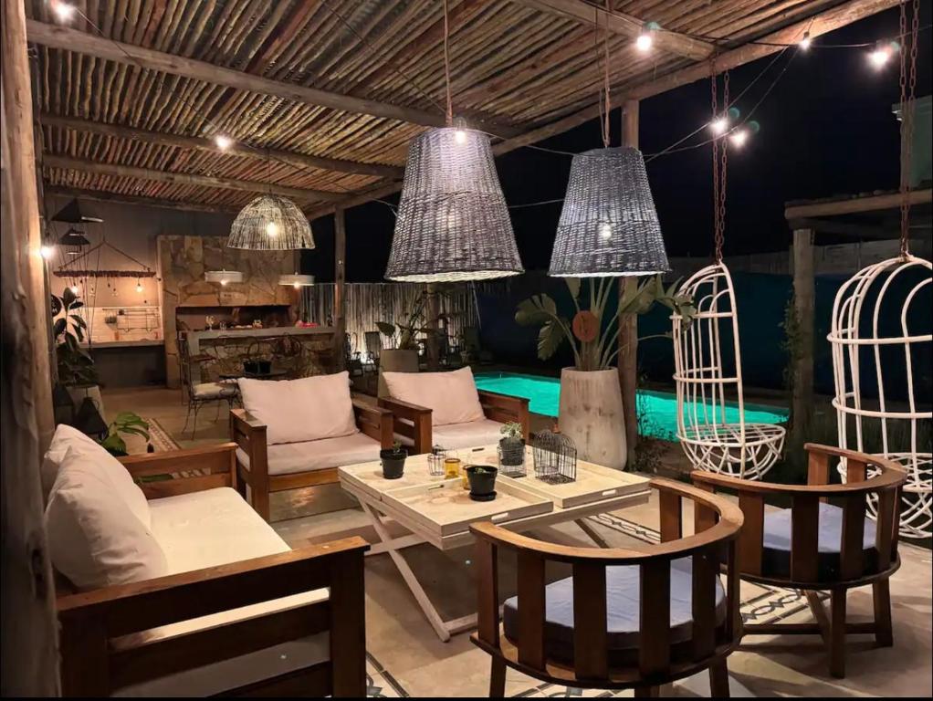 un soggiorno con tavoli, sedie e luci a ciondolo di Quincho de Ensueño! a Concordia