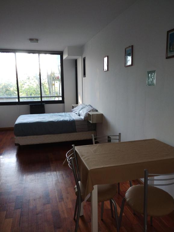 1 dormitorio con 1 cama, mesa y sillas en Departamento calle 2 en La Plata