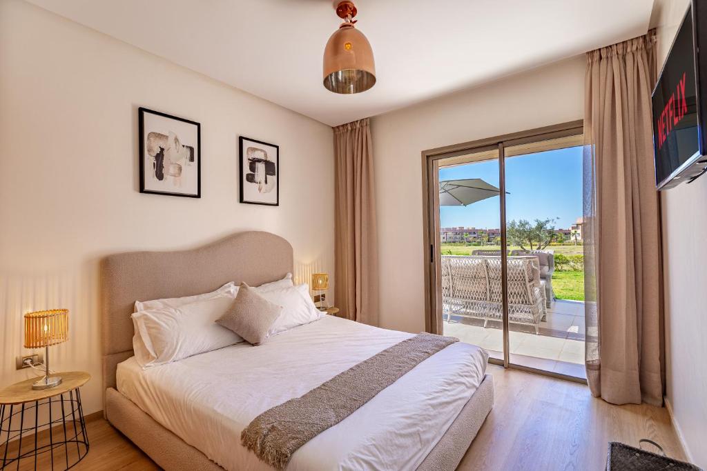 - une chambre avec un lit et une porte coulissante en verre dans l'établissement luxueux & spacieux appartement a prestigia, à Marrakech