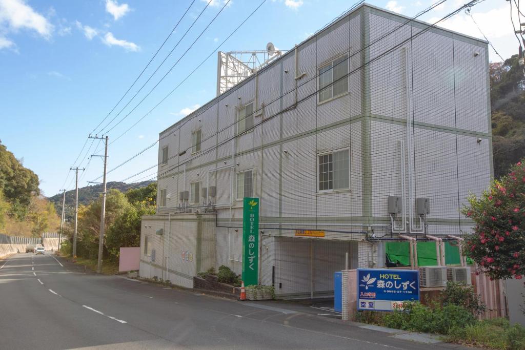 a large white building on the side of a street at ホテル森のしずく in Katsura
