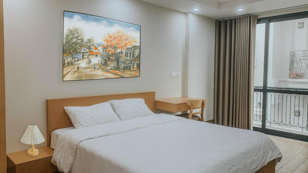 1 dormitorio con 1 cama y una pintura en la pared en Yen’s House en Hanói