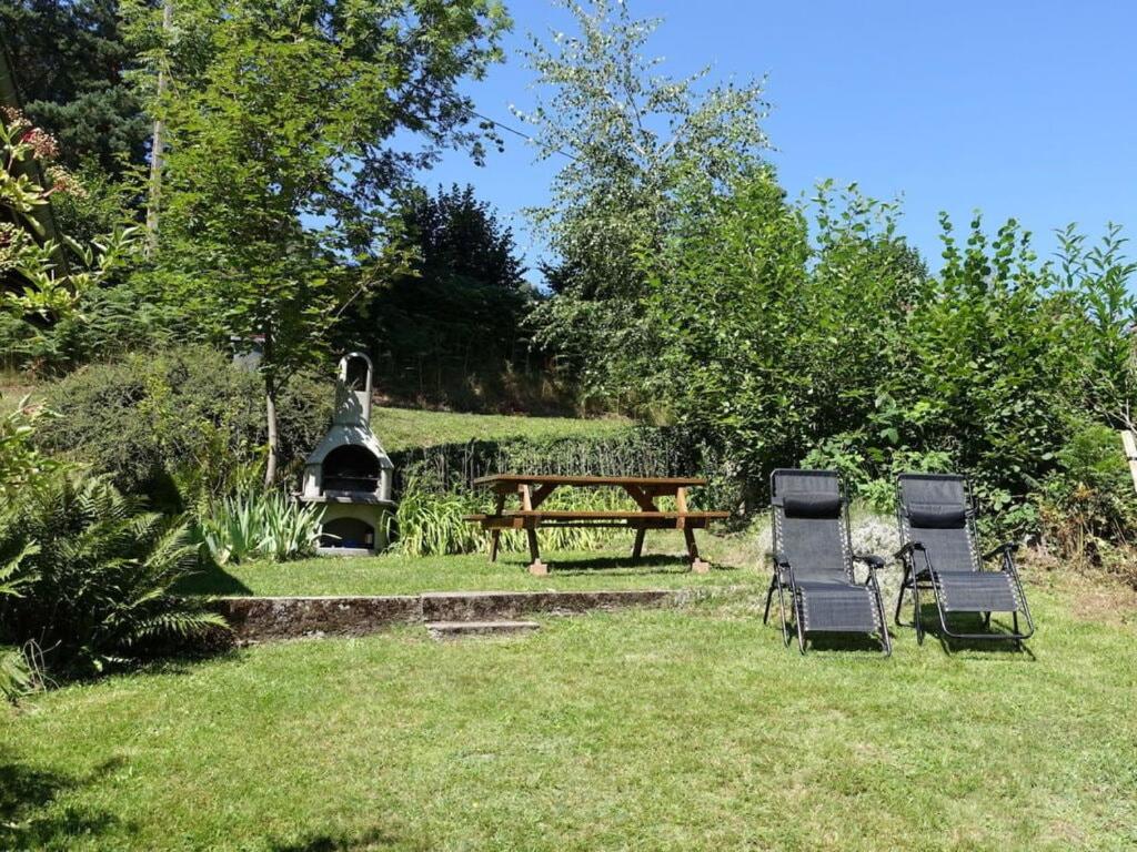 three chairs and a picnic table in a yard at Modern apartment in Soultzeren in Soultzeren