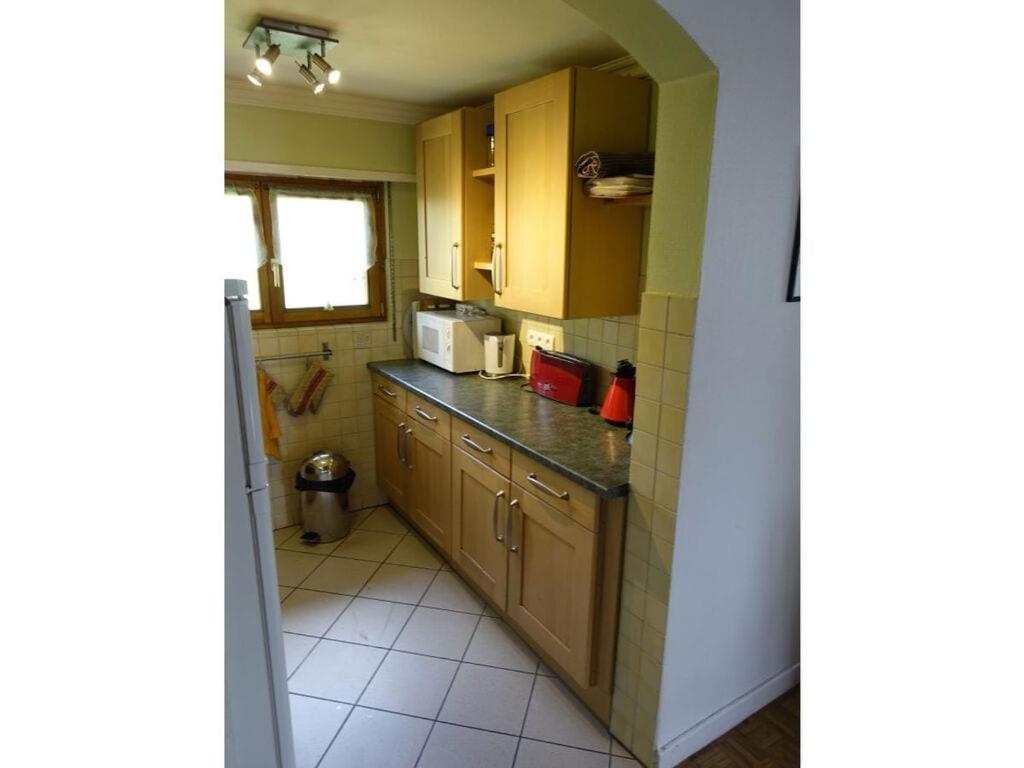 a small kitchen with wooden cabinets and a window at Modern apartment in Soultzeren in Soultzeren