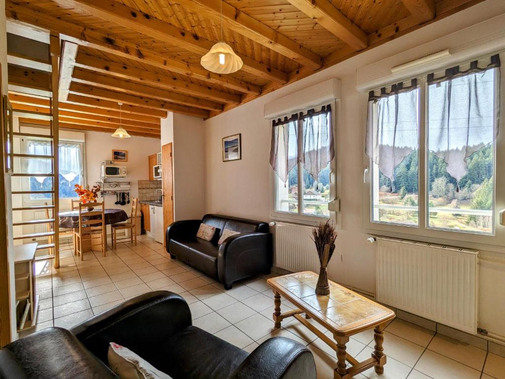 un salon avec des canapés et une table dans l'établissement Gîte à Gérardmer - Proche lac et pistes, Chem cheminée, 2 chambres - FR-1-589-108, à Gérardmer