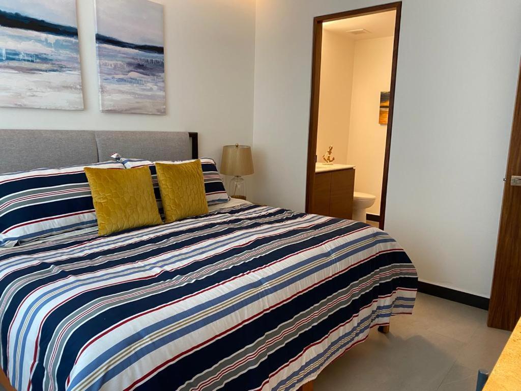 a bedroom with a large bed with yellow pillows at Casa Cielo Vallarta V-Golf in Puerto Vallarta