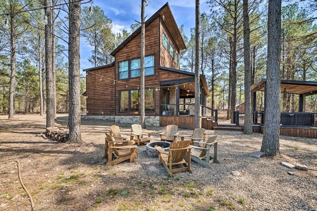 a cabin in the woods with chairs and a fire pit at Family Getaway 10-Bed Cabin w Hot tub & Firepit in Broken Bow