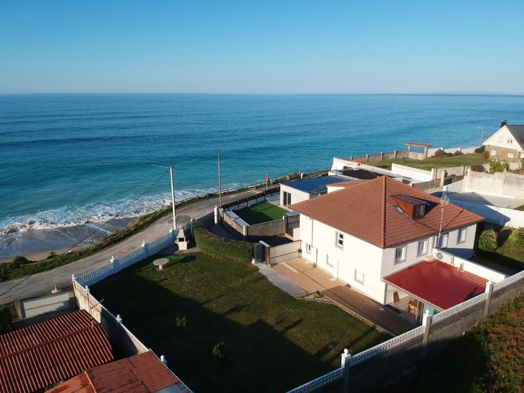 una vista aérea de una casa y del océano en AG Casa Vilamar en primera linea de playa Razo, en Razo da Costa