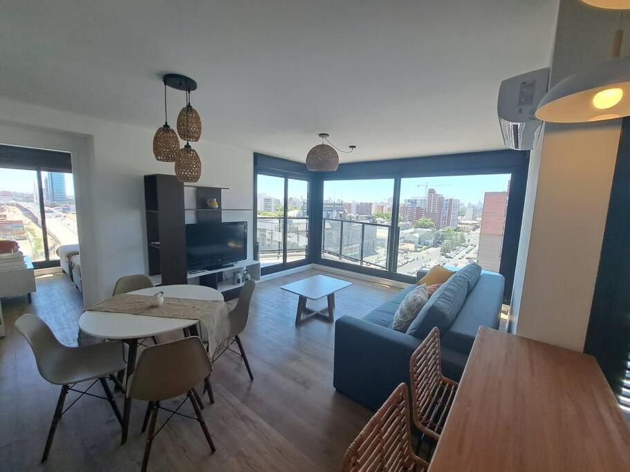 uma sala de estar com um sofá azul e uma mesa em 2 dormitorios, parking, gran vista em Montevidéu