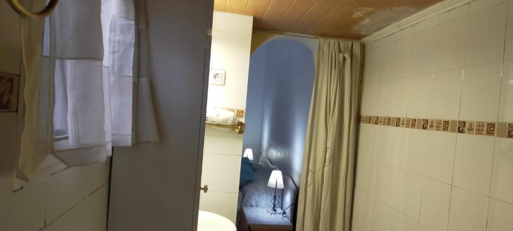 uma casa de banho com um WC e um chuveiro com uma janela em ALBORADA TRES em Burguillos