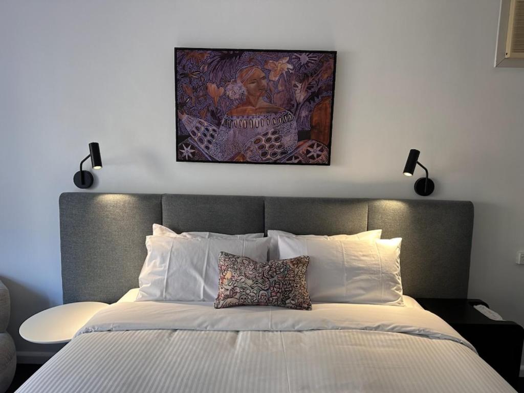 a bedroom with a bed with a painting above it at MAC St Kilda Acland by Melbourne Apartment Collection in Melbourne