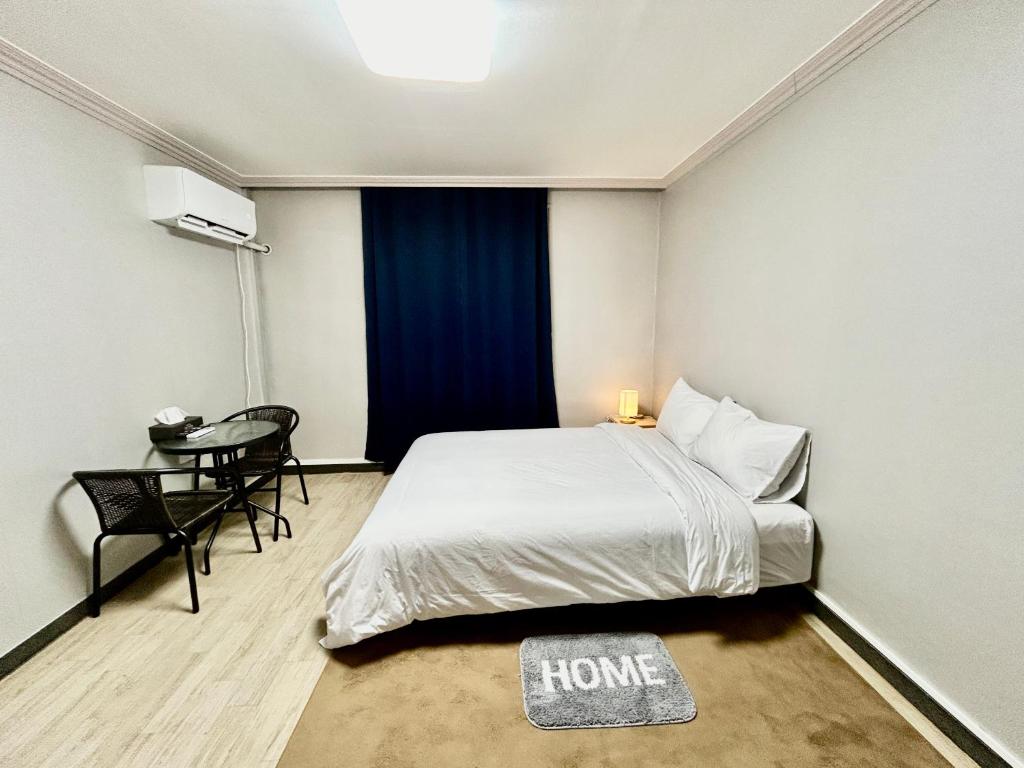 a small bedroom with a bed and a table at Royal motel in Goseong