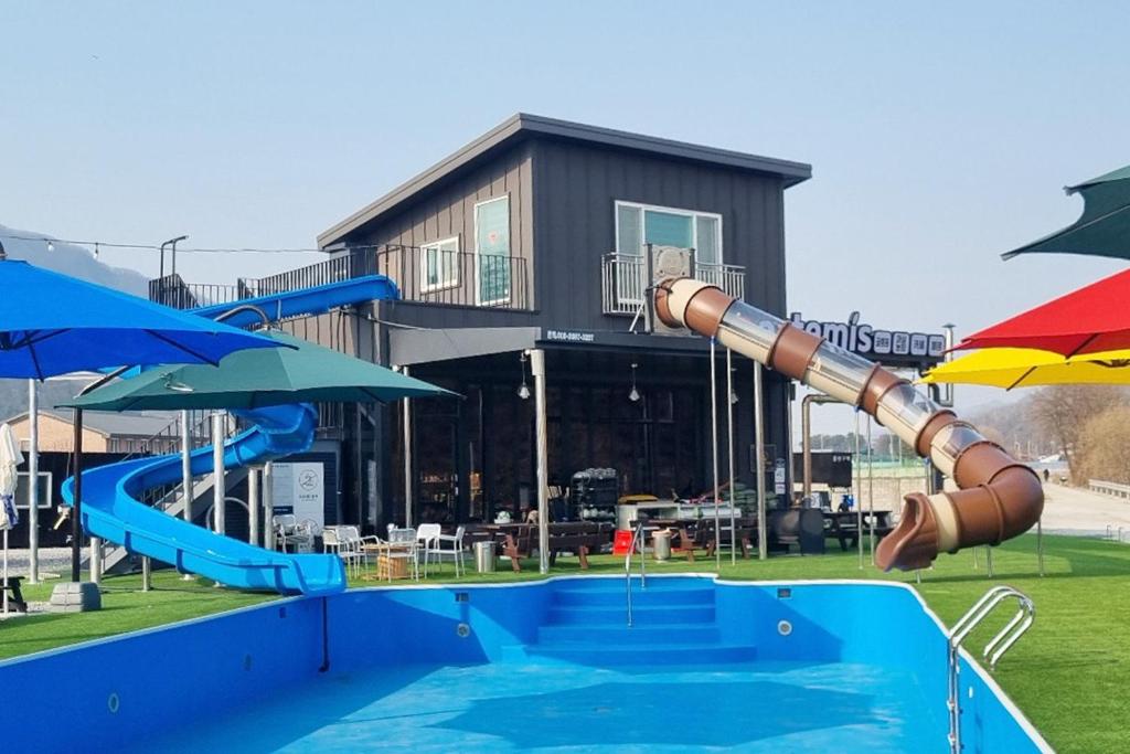 um parque infantil com escorrega aquático e guarda-chuva em Pocheon Artemis Glamping em Pocheon