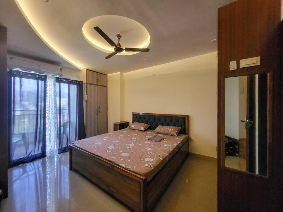- une chambre avec un lit et un ventilateur de plafond dans l'établissement Cozy Heaven (1-Room)BW, à Guwahati