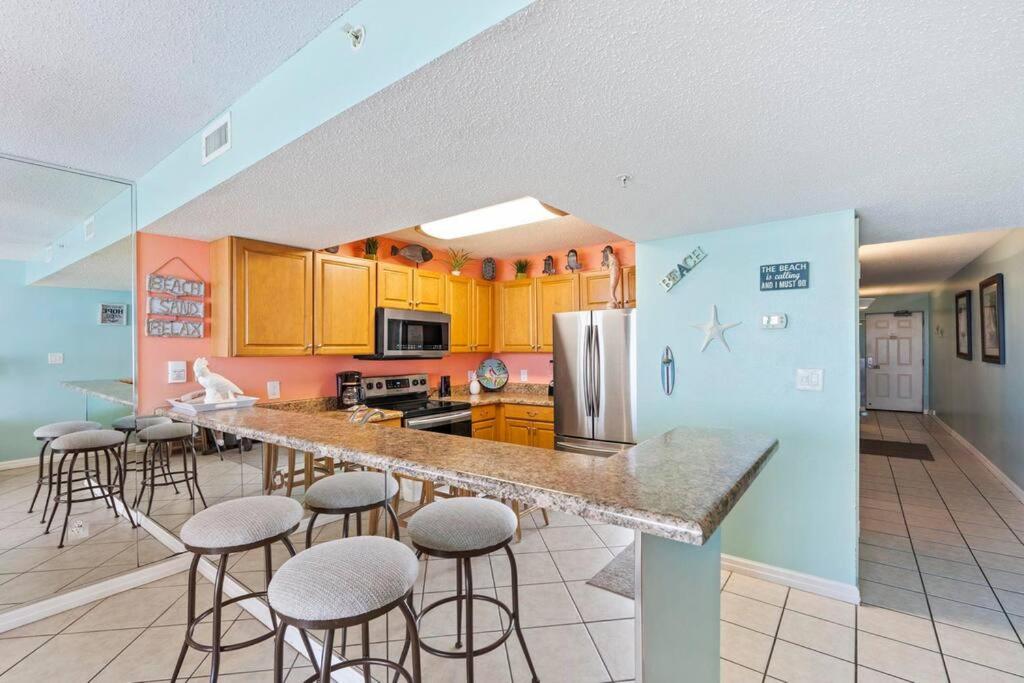 eine Küche mit einer Theke und Hockern in einem Zimmer in der Unterkunft Beachfront condo at Pelican Beach in Destin