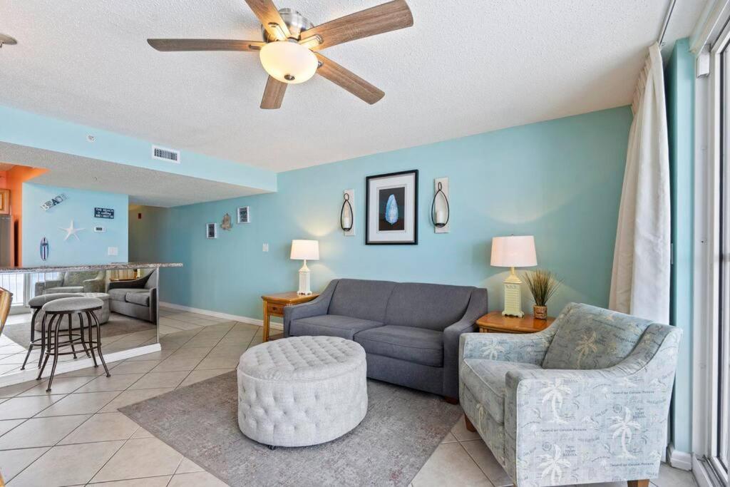 ein Wohnzimmer mit einer Couch und einem Deckenventilator in der Unterkunft Beachfront condo at Pelican Beach in Destin