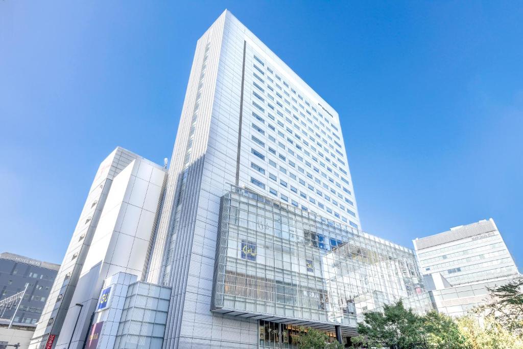 um edifício de vidro alto numa cidade em remm Akihabara em Tóquio