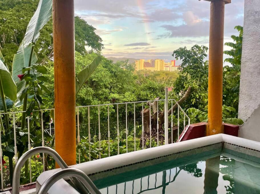 einen Balkon mit Pool und Stadtblick in der Unterkunft Amplio departamento con Jacuzzi privado. in Ixtapa