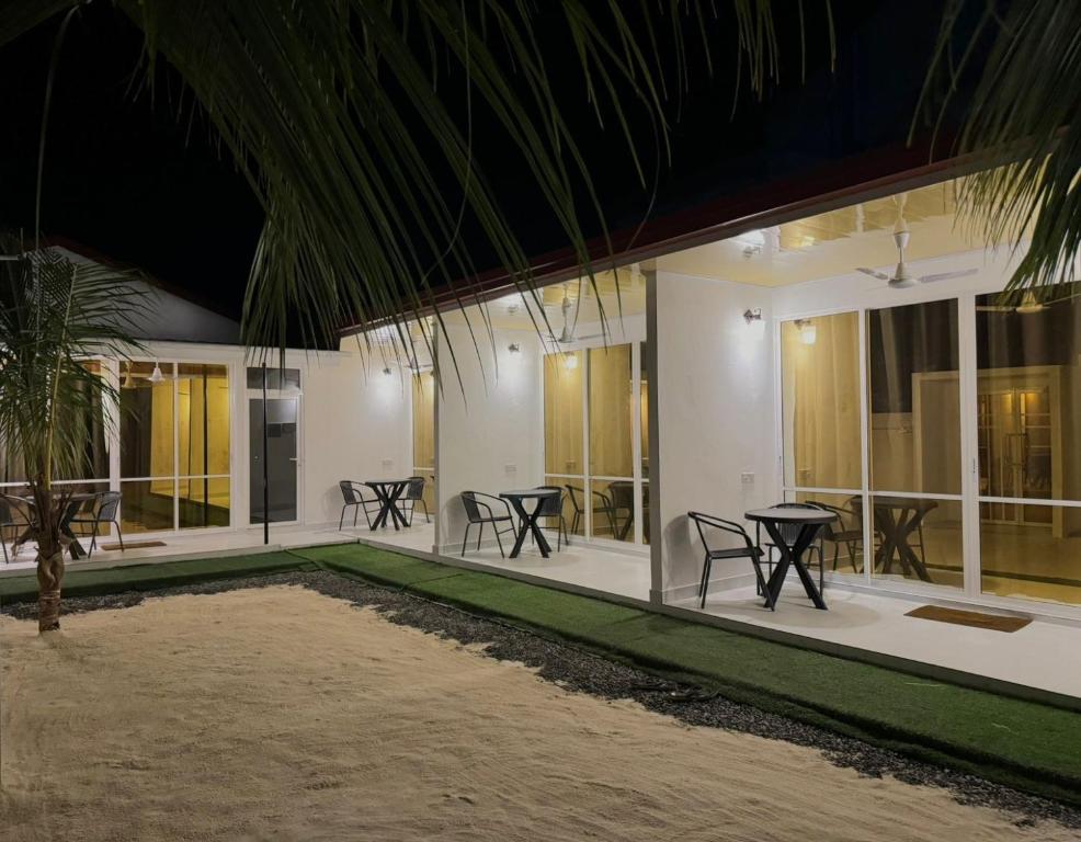 Vegas Thoddoo Maldives في ثودو: غرفة مع طاولات وكراسي في مبنى