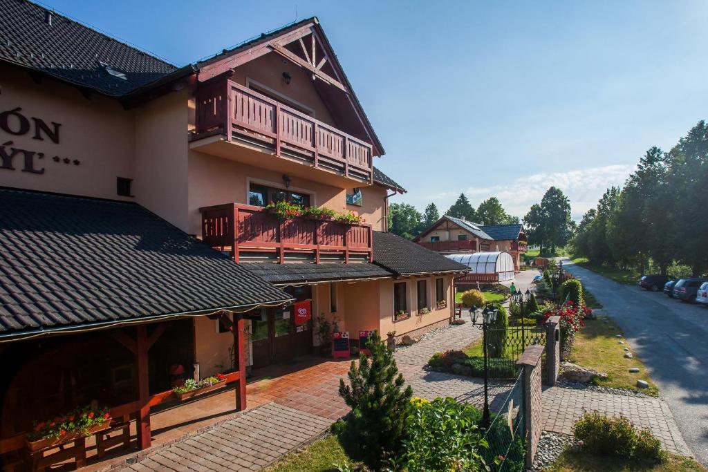 - un bâtiment avec balcon sur le côté d'une rue dans l'établissement Penzion Motyl, à Bešeňová