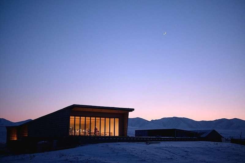 a building with large windows with mountains in the background at Yeruu lodge in Jargalant