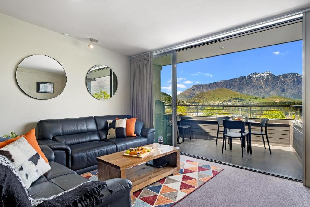 a living room with a couch and a table at Tahuna Views in Queenstown