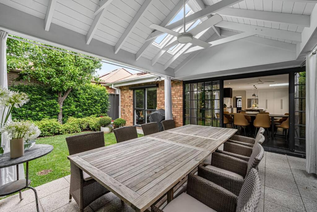 a patio with a wooden table and chairs at Iris at Norwood - Luxe Indoor-Outdoor Living near CBD in Norwood