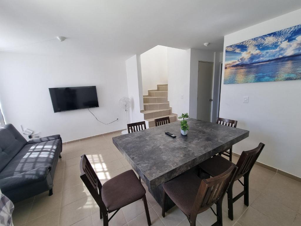 uma sala de jantar com uma mesa e cadeiras e um sofá em Casa amplia Garde SD em Querétaro