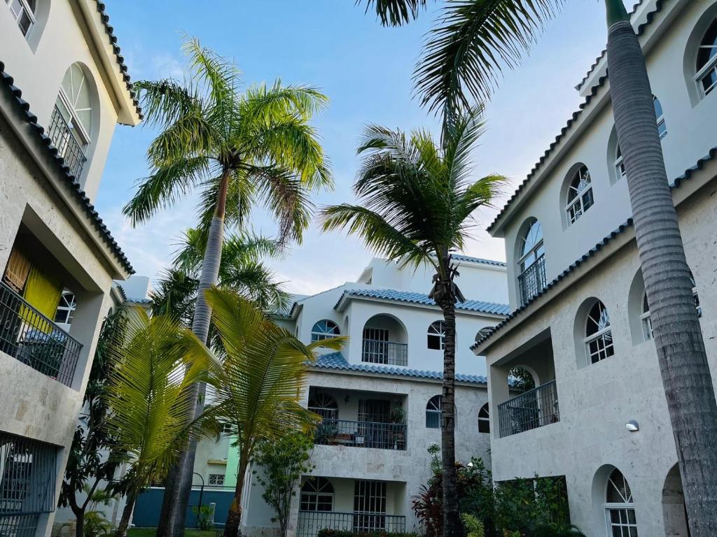 un edificio con palmeras delante en paradise close to the beach pool free parking,wifi- punta cana, en Punta Cana
