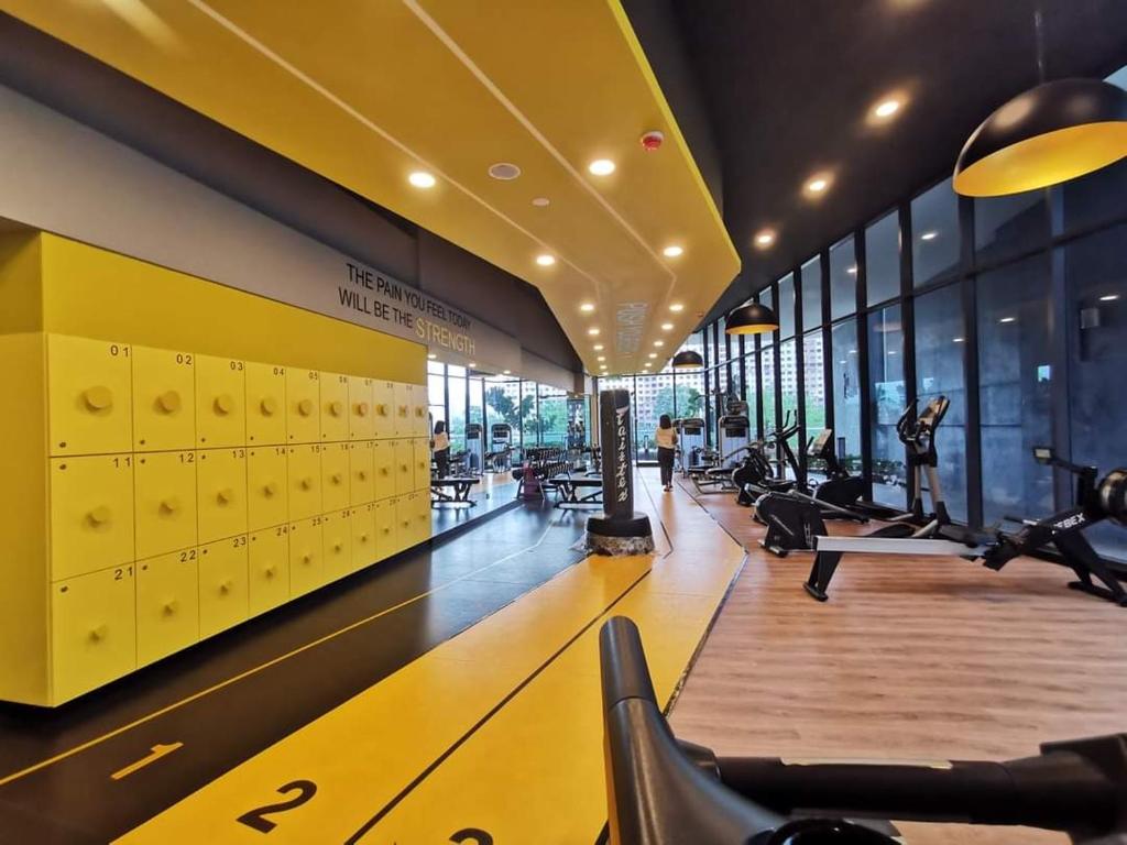 Private Room Bukit Bintang في كوالالمبور: صالة ألعاب رياضية مع أجهزةٍ جري في مبنى