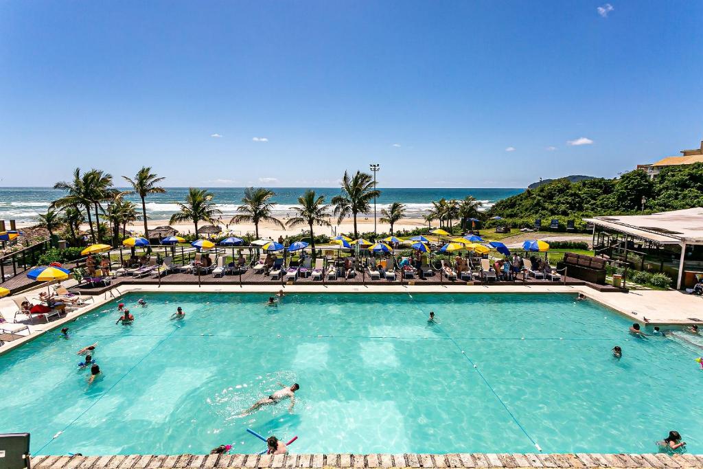 - une grande piscine avec des personnes à côté d'une plage dans l'établissement Flat vista mar dentro de resort de luxo STO2206, à Florianópolis