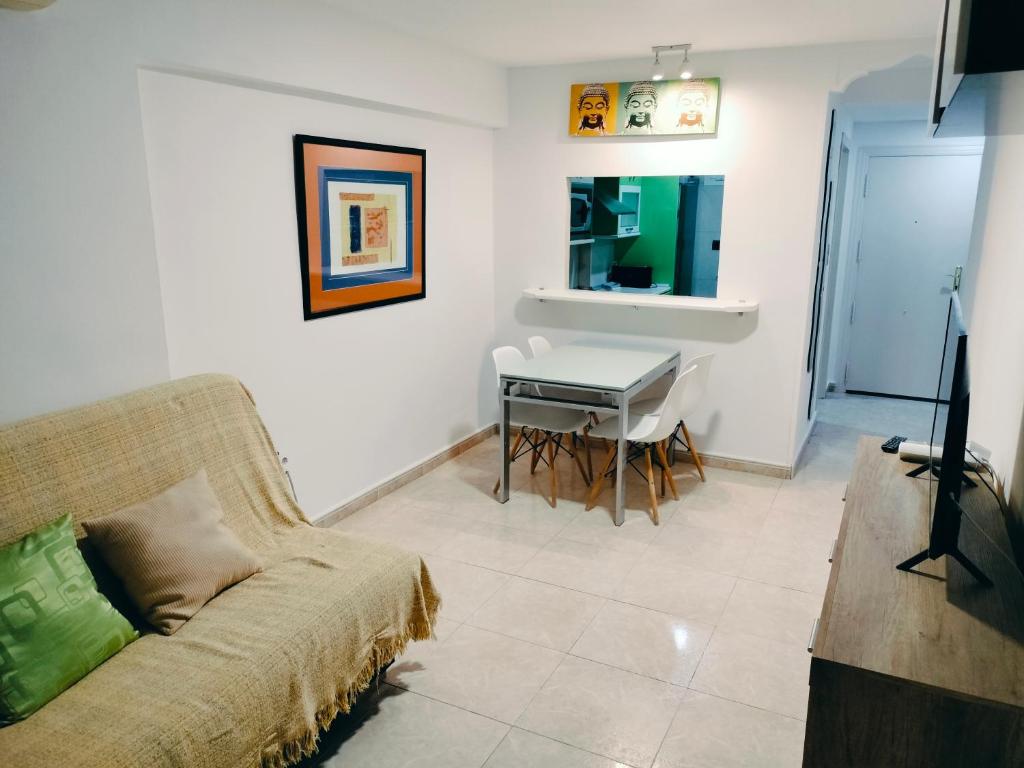 a living room with a couch and a table with a piano at apartamento moderno in Benidorm