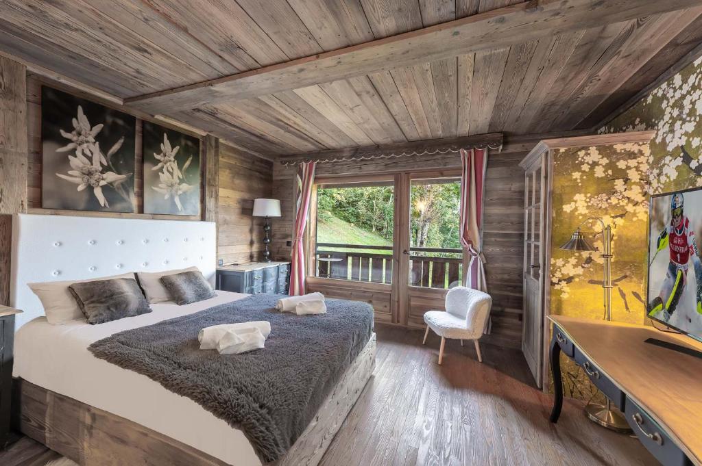 a bedroom with a bed and a desk and a window at SOMPTUEUX CHALET BARON MEGEVE VUE.Jaccuzi.4 mn a pied au centre in Megève