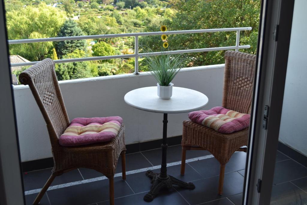 einen Balkon mit einem Tisch, 2 Stühlen und einem Tisch in der Unterkunft Ferienwohnung Am Steinberg in Hildesheim