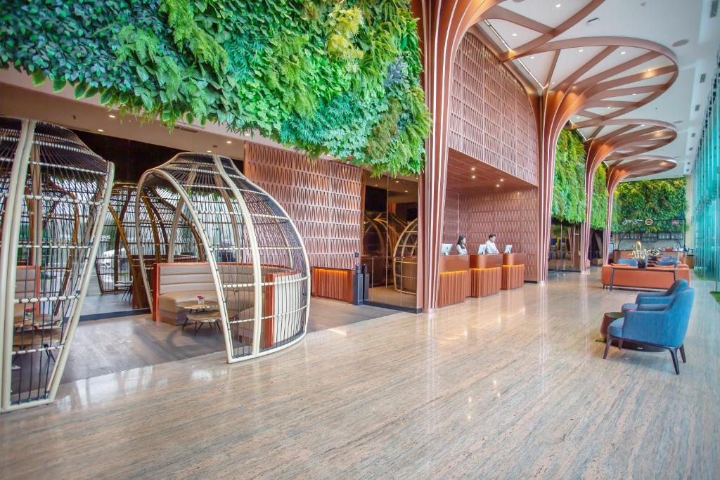 eine Lobby eines Gebäudes mit grüner Decke in der Unterkunft HARRIS Hotel & Conventions Gubeng in Surabaya