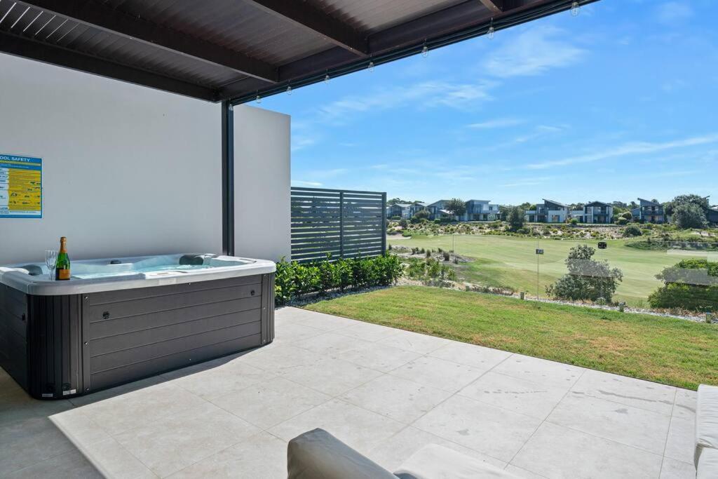 a patio with a tub and a view of a golf course at Mi Casa Magenta in Magenta