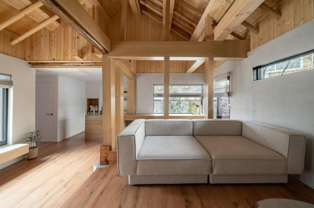 una sala de estar con sofá en una habitación con techos de madera en Han Yul Jae - Hanok, en Chuncheon