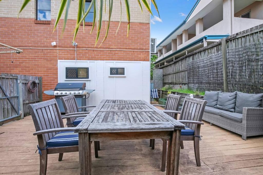 a wooden table and chairs on a patio at The Sunny Studio - A Peaceful Riverside Abode in Brisbane