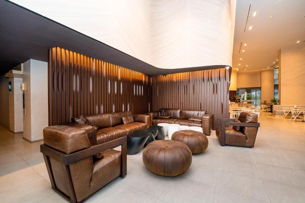 A large lobby lounge furnished with leather sofas, armchairs and low ottomans.