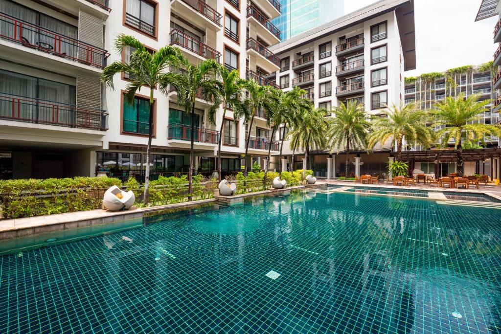 Palm-lined pool water stretches alongside the hotel residences and landscaped deck.