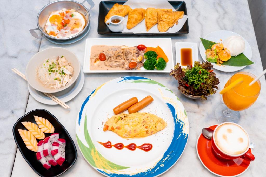 A generously styled breakfast spread with hot dishes, fruit, pastries and drinks.
