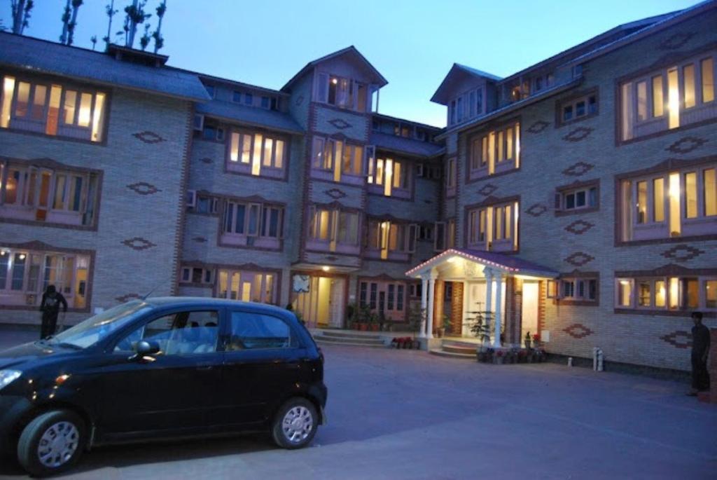 ein kleines Auto, das vor einem Gebäude geparkt ist in der Unterkunft Hotel Sterling , Srinagar in Srinagar