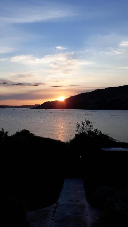 un coucher de soleil sur une grande étendue d'eau dans l'établissement The Views, à Dunedin