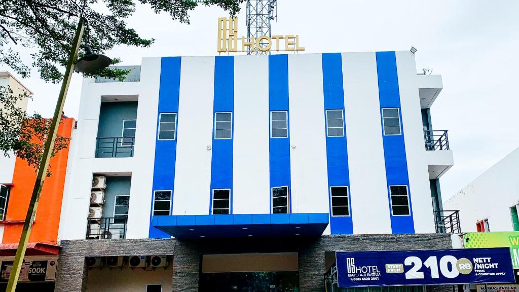 ein weißes und blaues Gebäude mit einem Schild oben in der Unterkunft OS Hotel Batu Aji Batam in Batam Center