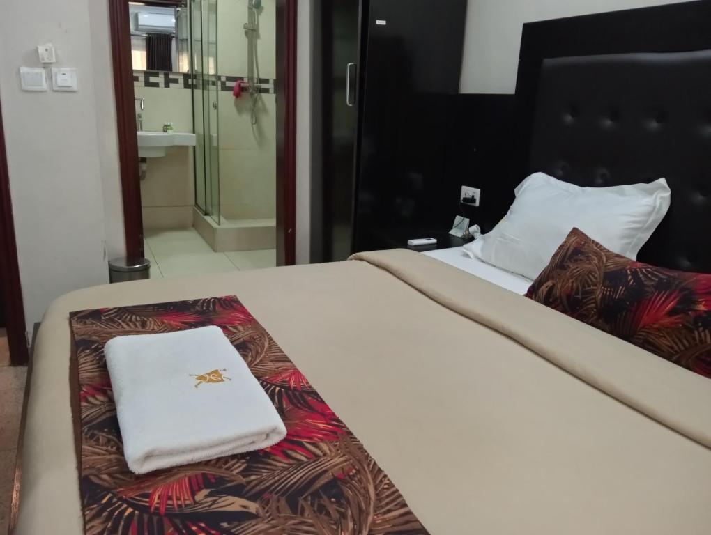 uma cama com uma toalha branca em cima em The Lodge-Stack By Kabachi em Lagos