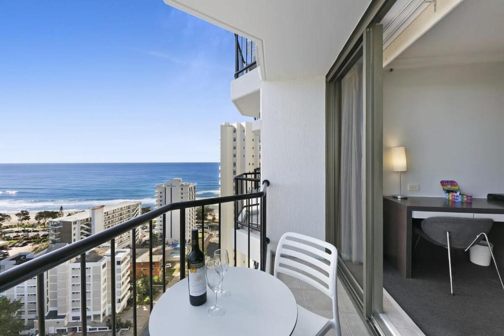 a balcony with a table and chairs and the ocean at Ocean View 2-Bed Studio In the Heart of Surfers in Gold Coast