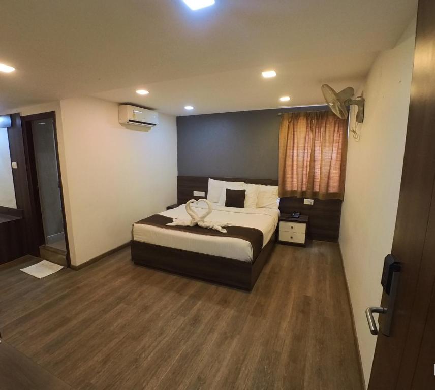 a bedroom with a large bed in a room at Hotel Royal Inn - Electronic City in Bangalore