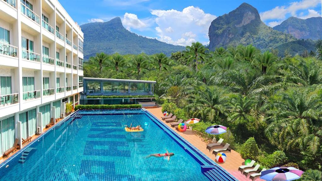 una piscina en un hotel con montañas en el fondo en The Pano Hotel And Residence, en Ban Khlong Haeng