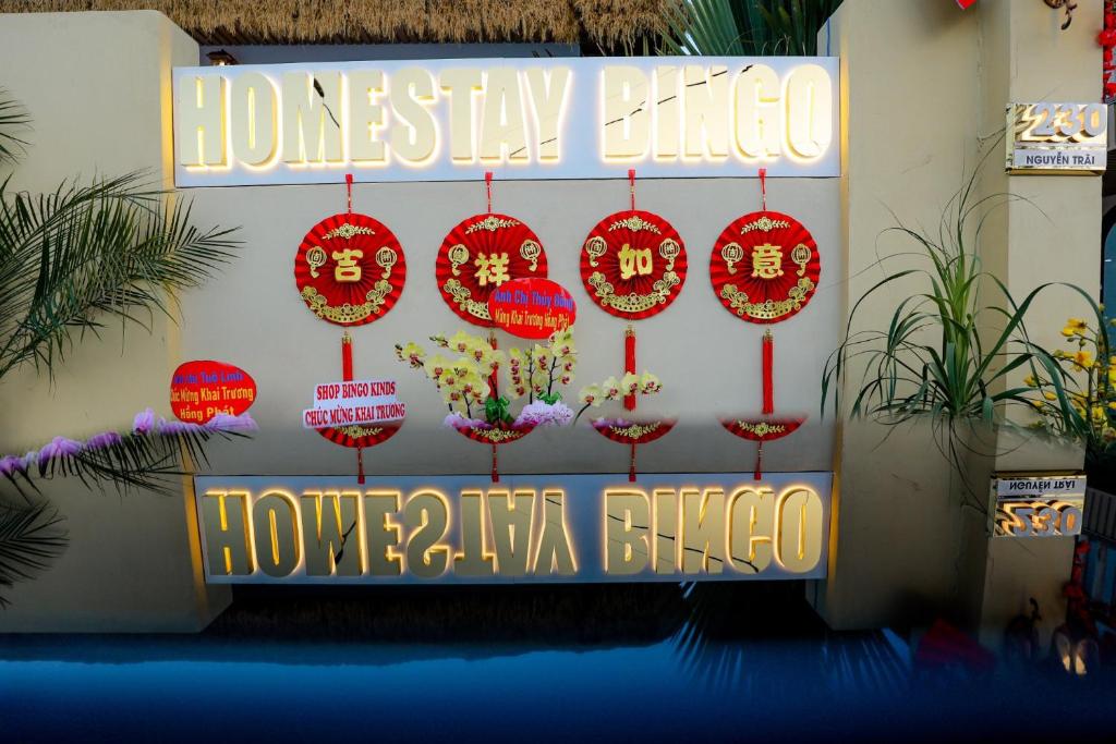 um sinal para um hotel com decorações em vermelho e amarelo em Homestay Bingo LaGi 2 em Tân Tạo